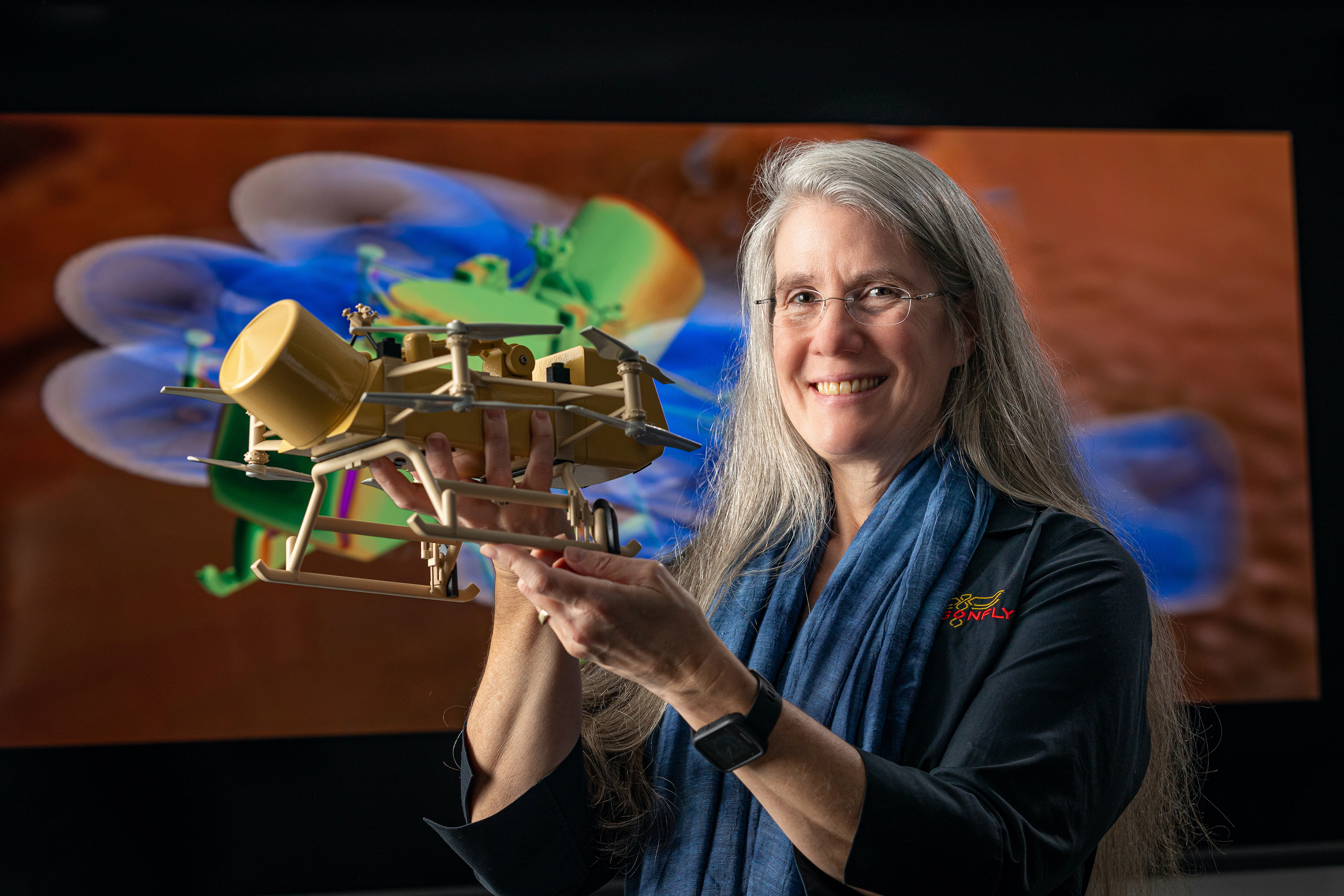 Elizabeth "Zibi" Turtle holds a small replica of NASA's Dragonfly spacecraft