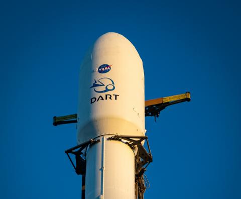 The SpaceX rocket carrying DART sits on the launch pad with the DART and NASA logos apparent