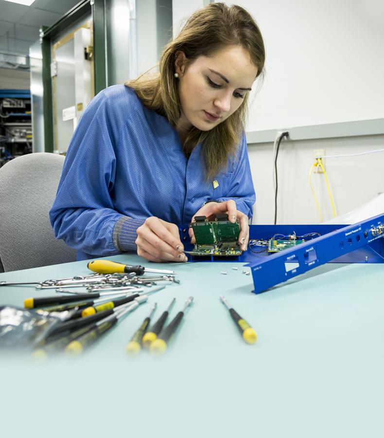 Image of an APL engineer working on an electronic board