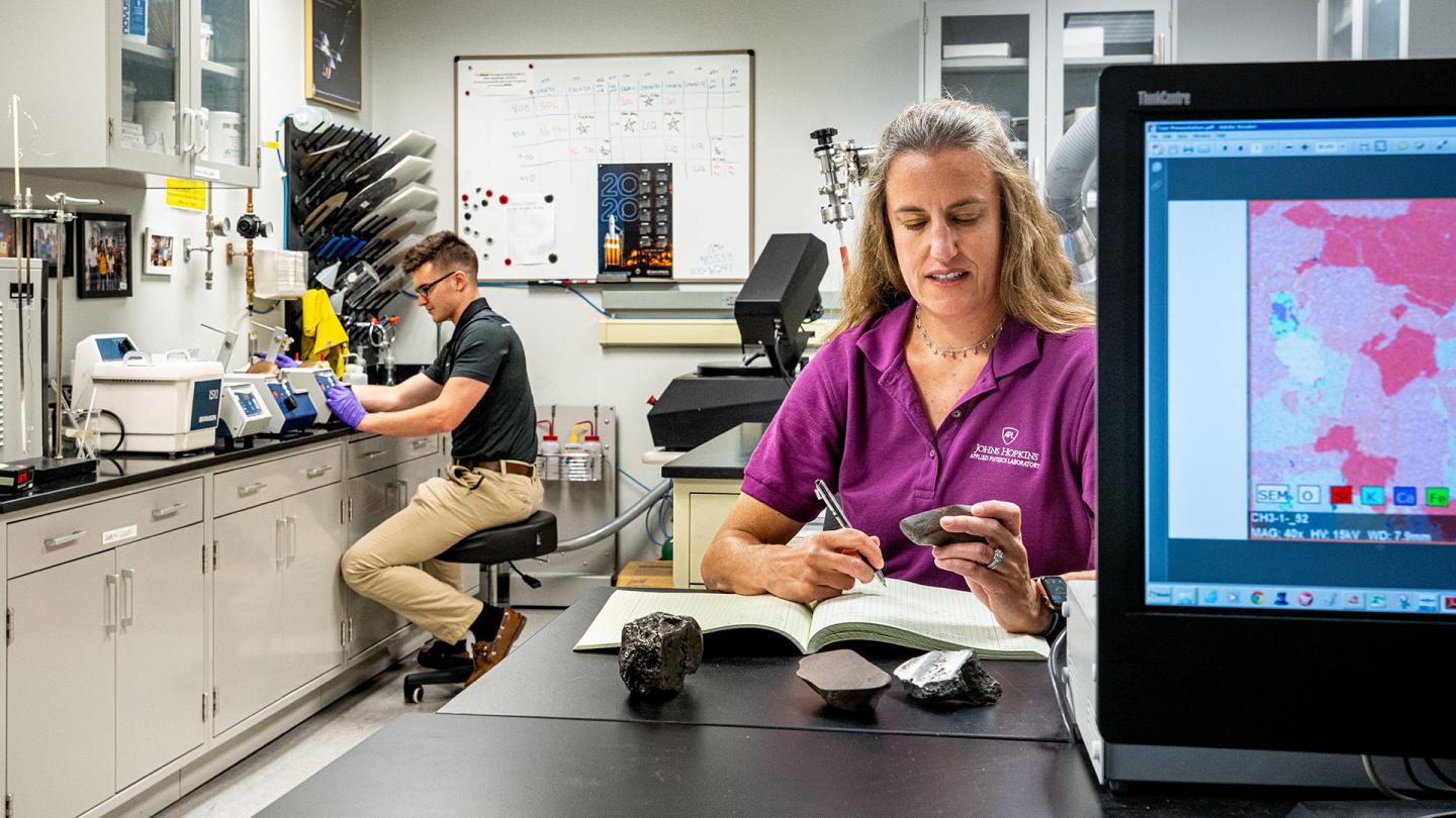 Two scientists examining meteorite samples in the Meteorite Lab